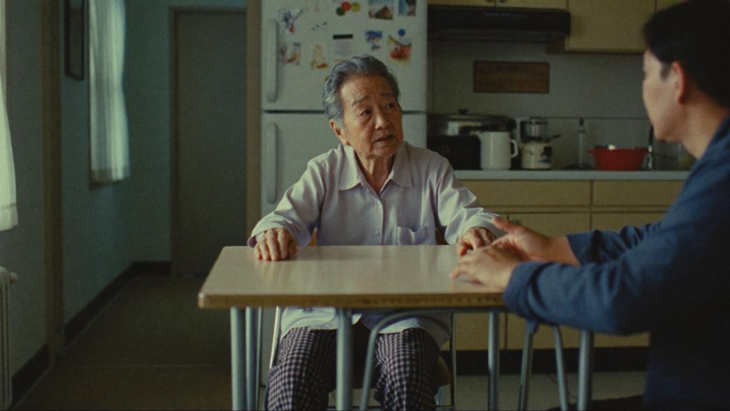 Mdm Tan, 82, talks across her kitchen table to one of our interviewers.
